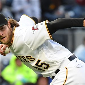 Gerrit Cole throws to first against the Brewers in May.