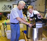  Dr. Bill and Donna Bookwalter use a honeycomb spinner to collect honey at their garage in Fox Chapel.