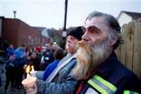  Perry Ackerman, a brother-in-law of one of the victims, attends a vigil Sunday for the those who died Saturday in a McKees- port fire.