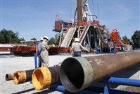  In this 2011 file photo, Range Resources workers stand near a rig that drills into shale at a well site in Washington, Pa.