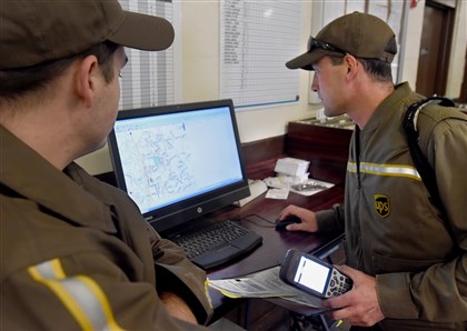 20151103radUPSBiz06-5 Delivery Information Acquisition Devices (DIAD) in hand, UPS drivers check the computer depiction of their routes before leaving on the day's deliveries at the UPS depot in Jackson, Butler County.