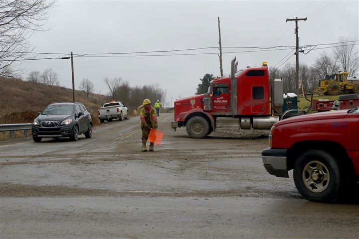 20170126ppSoBeltway4LOC-3 A worker with Independence Excavating from Cleveland directs traffic at the intersection of Route 980 near Quicksilver Road in McDonald, Washington County.