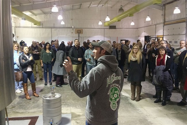  Shawn Strickland explains the brewing process to attendees of the opening of the new brewing facility of Voodoo Brewing Co. in Meadville.   