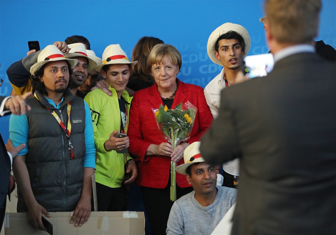 German Chancellor Angela Merkel, a Christian Democrat, poses for a photo with Syrian refugees after she spoke at an election campaign stop Sept. 19 in Schwerin, Germany.