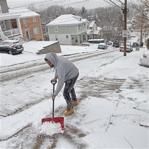 Calvin Miller shovels and salts the sidewalk Wednesday in front of his home on Fallowfield Avenue in Beechview.
