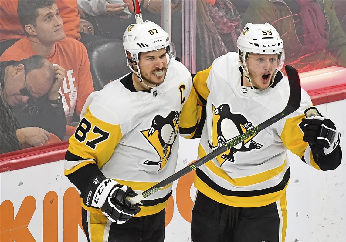 Jake Guentzel celebrates with Sidney Crosby after scoring the first of his four consecutive goals Sunday in an 8-5, series-clinching victory against the Philadelphia Flyers.