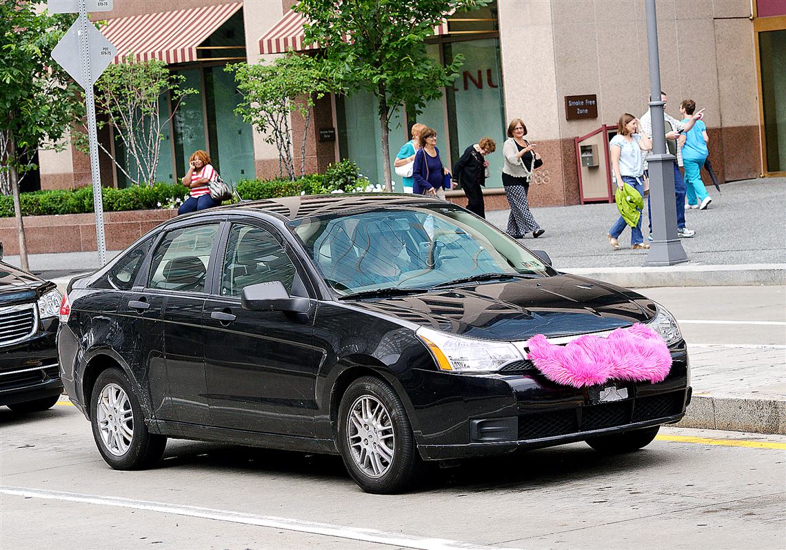 A car sporting the Lyft mustache on its grill is seen on Commonwealth Place in Downtown.