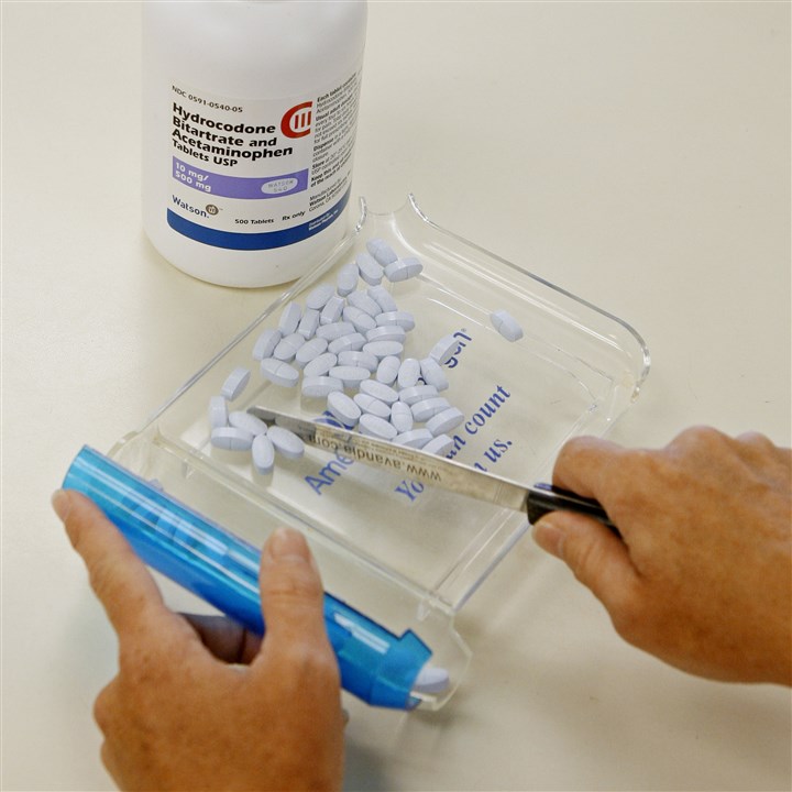 Prescription Painkillers-New Warnings A pharmacy technician counts prescription medication at a pharmacy in Edmond, Okla.