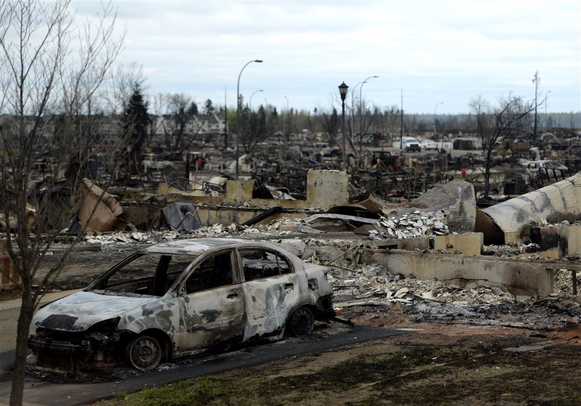 A burned out car and houses are viewed in the Beacon Hill neighborhood during a media tour of the fire-damaged city of Fort McMurray, Alberta, Monday, May 9, 2016. A break in the weather has officials optimistic they have reached a turning point on getting a handle on the massive wildfire. (Jonathan Hayward/The Canadian Press via AP) MANDATORY CREDIT