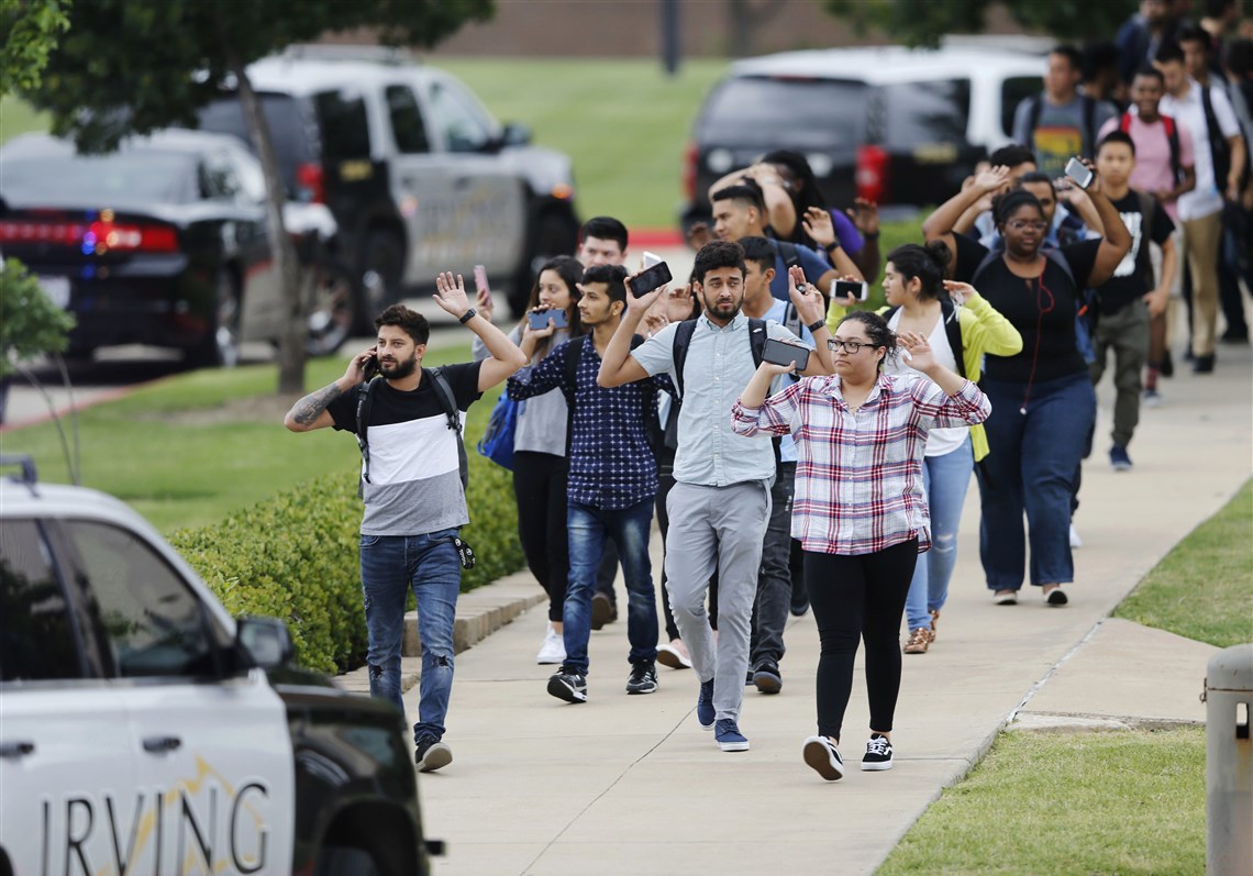 Students and faculty exit a building with their hands up after a fatal shooting at North Lake College in Irving, Texas, on Wednesday. Multiple people died in an apparent murder-suicide at the college, prompting an active-shooter alert that instructed students and employees to barricade themselves into rooms.
