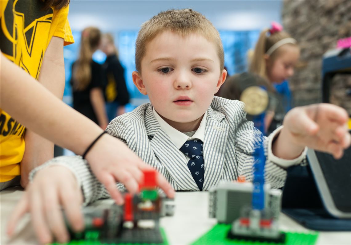 Kindergartner Brayden Price, 6, works on a set of Legos that are powered by simple motors and circuits as he tests out the world's first Brick Makerspace on Thursday at Montour Elementary School in McKees Rocks.  Fourth-grader Ellyson Sleva, 10, of Robinson, is familiar with the electricity powered sets, her class has already tested them out. 