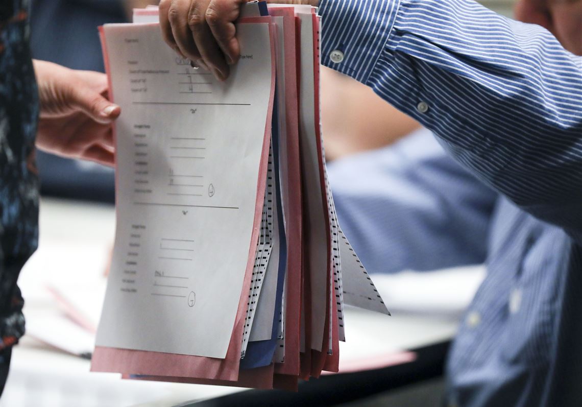 Paul Taimuty, of Allison Park, hands a stack of absentee ballots to Melanie Ostrander, of the Washington County Elections Office, in 2018.